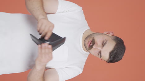 Vertical-video-of-Penniless-man-looking-at-his-empty-wallet.